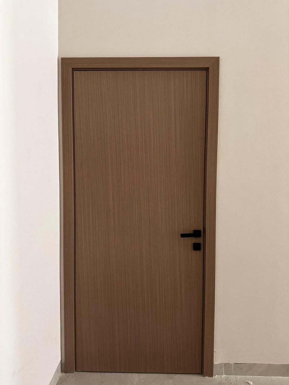 Natural wood tone interior door with dark handle