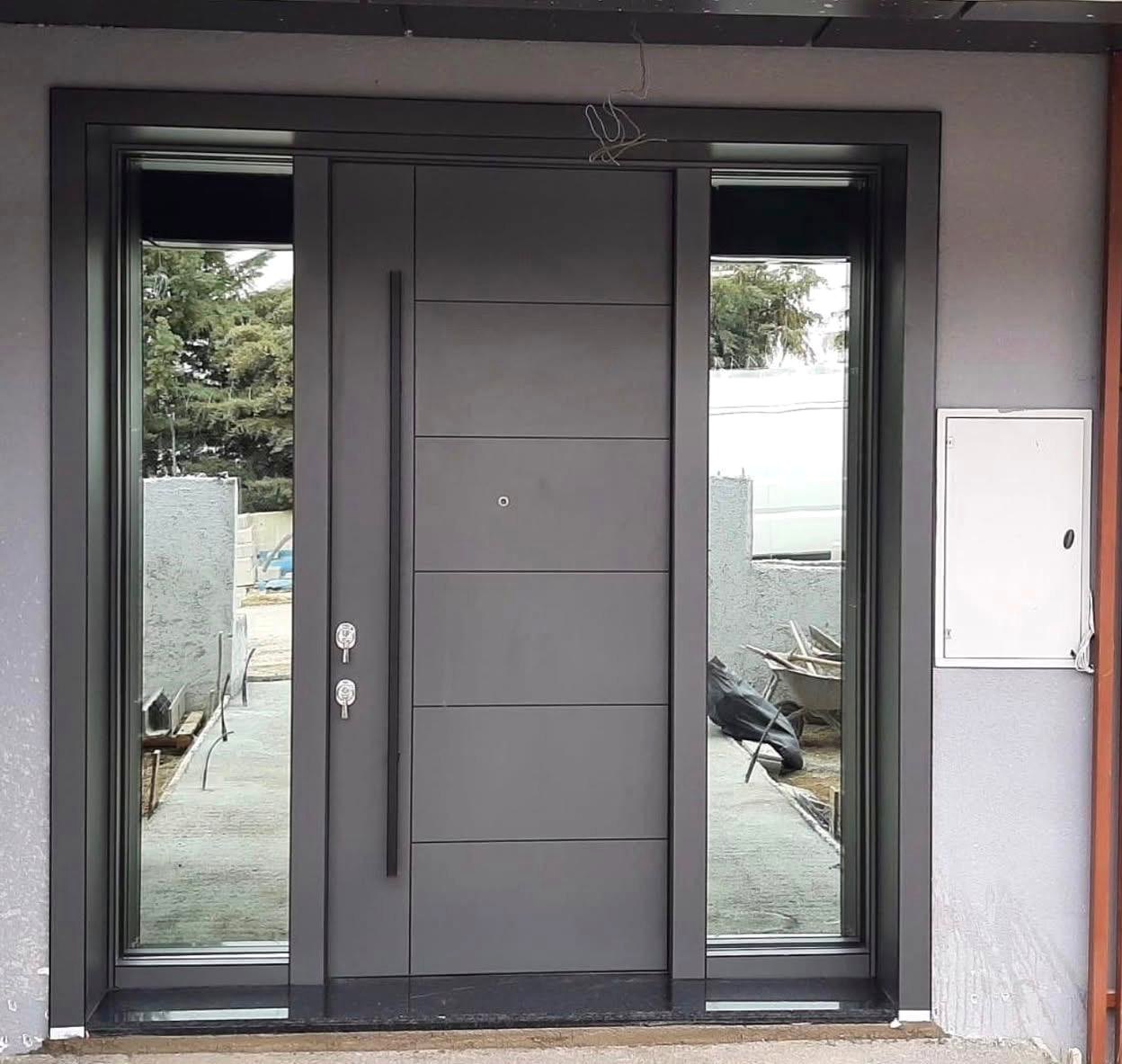 Large grey pivot entrance door with side glass panels