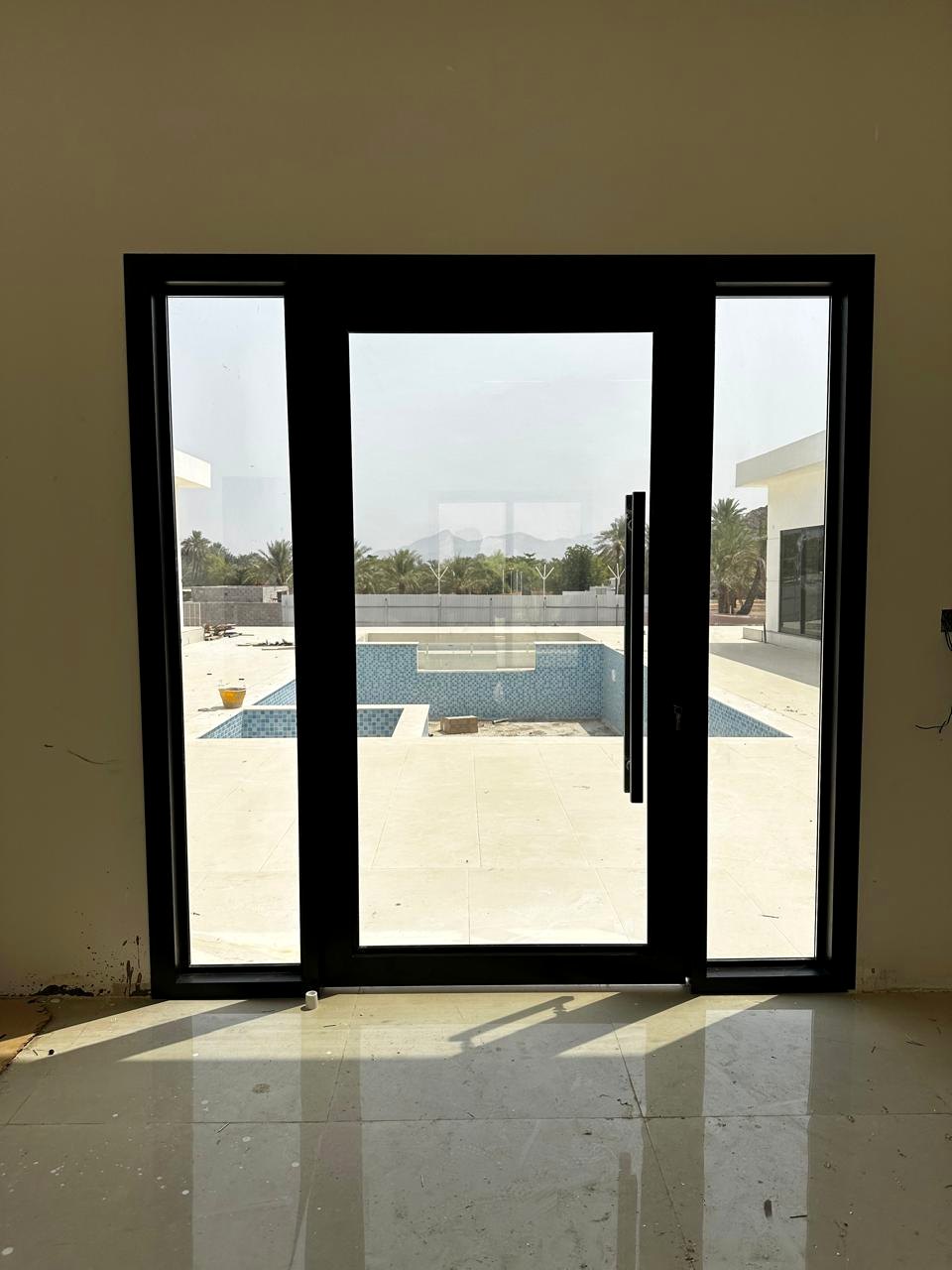 Black aluminium sliding glass doors overlooking a pool
