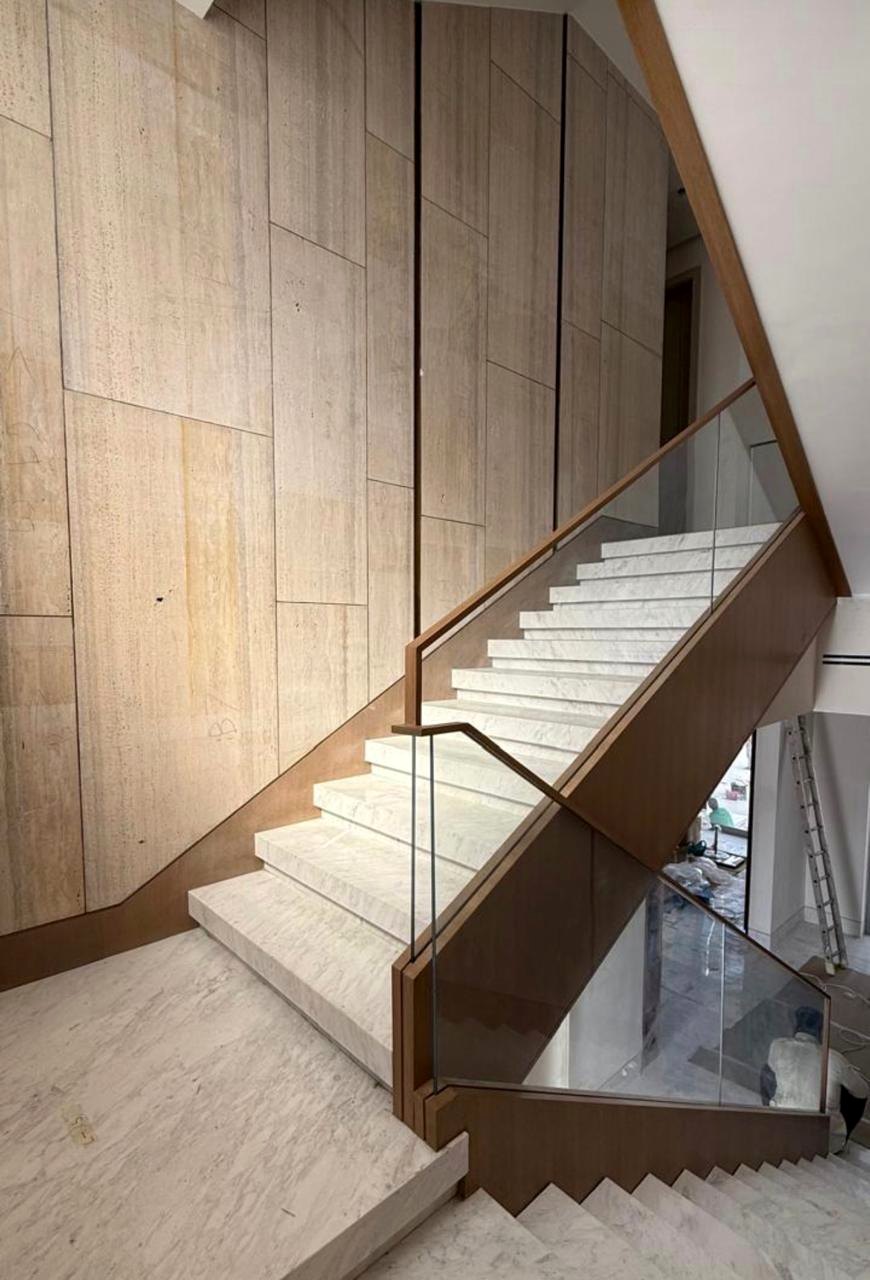 Interior stone staircase with timber wall and glass balustrade